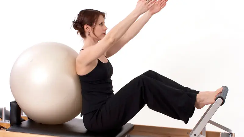 Aluna 50+ realizando exercício de fortalecimento seguro no Pilates