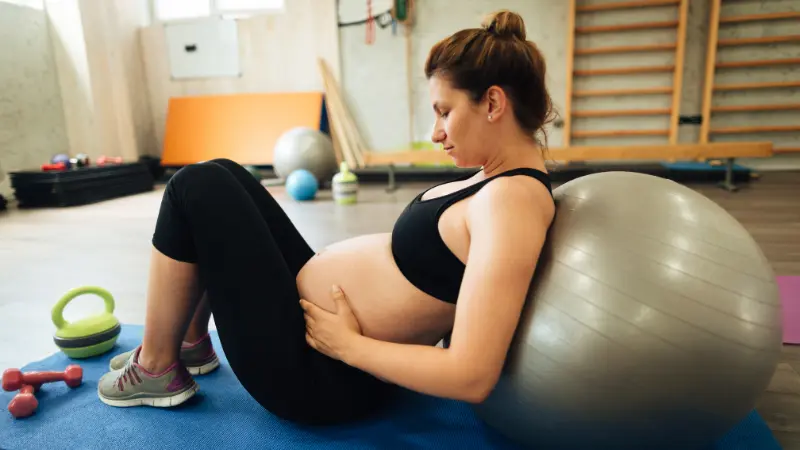 Gestante realizando exercício com foco em mobilidade e sustentação